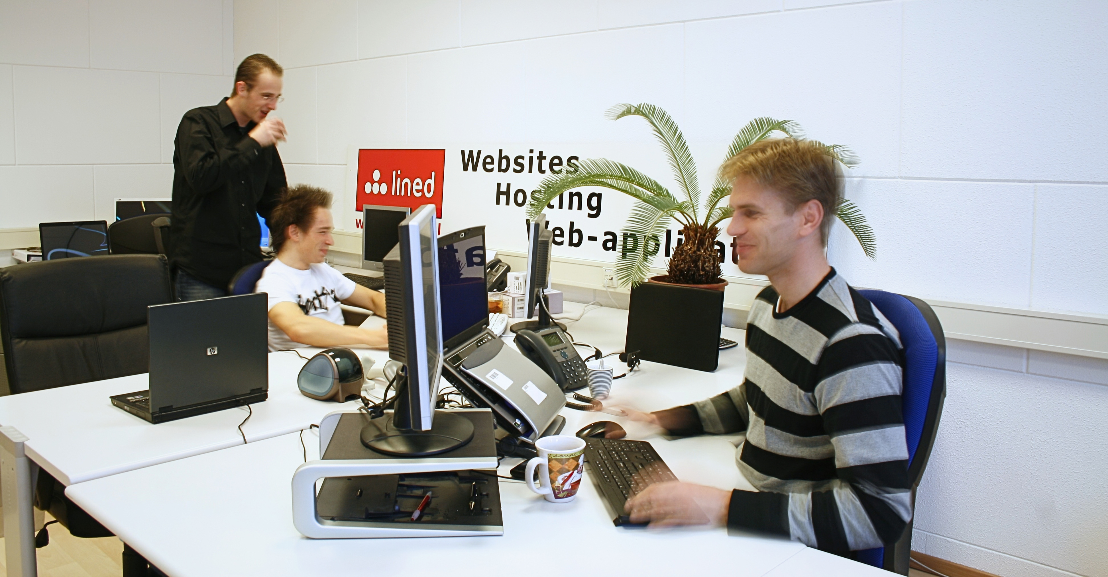 Medewerkers van Lined aan het werk op kantoor achter hun computers